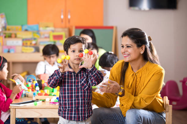 teacher having fun with preschool student in classroom